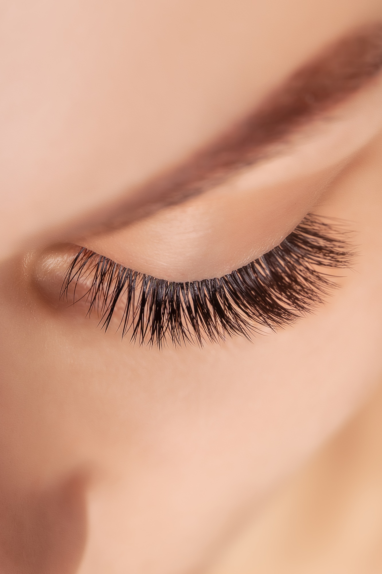 Eyelash Extension Procedure. Woman Eye with Long Eyelashes. Close up, selective focus